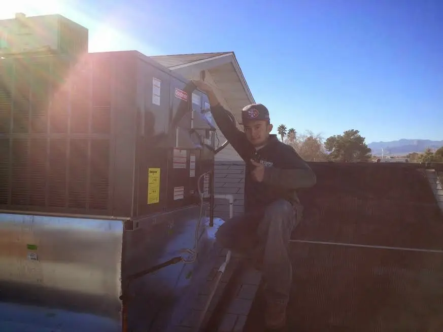 HVAC technician performing Heat Pump Repair on a rooftop unit in Hickory Creek